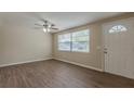 Bright living room showcasing new floors, a ceiling fan, and natural light coming through a large window at 4129 Highland Loop, New Port Richey, FL 34652