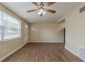 Bright, airy living room featuring new floors, a ceiling fan, and a front entrance door at 4129 Highland Loop, New Port Richey, FL 34652
