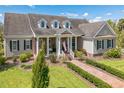 Lovely home featuring neutral siding, brick accents, a welcoming front porch, and meticulously maintained landscaping at 1570 Oakford Rd, Sarasota, FL 34240