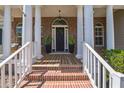 Inviting front porch with brick steps, stately columns, and a stylish front door with decorative plants at 1570 Oakford Rd, Sarasota, FL 34240