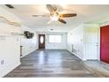 Spacious living room with new gray wood flooring, an entry door, and a bright window at 10105 Vineyard Ln, Port Richey, FL 34668