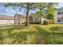 Attractive one-story home with a red door, an attached garage, and lush front lawn with mature landscaping at 13004 Waterbourne Dr, Gibsonton, FL 33534