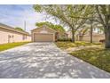 Inviting one-story home with a long driveway, well-manicured lawn, and an attached two-car garage at 13004 Waterbourne Dr, Gibsonton, FL 33534