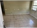 Spacious living room with neutral tile floors and natural light from a large window at 2918 E Waters Ave, Tampa, FL 33604