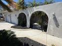 Arched entry with wrought iron gate leads to front door of home at 3747 Floramar Ter, New Port Richey, FL 34652