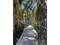 Gated entrance to walkway with pavers and mature landscaping at 3747 Floramar Ter, New Port Richey, FL 34652