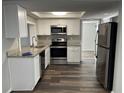 Modern kitchen with stainless steel appliances, granite countertops, and white cabinets, perfect for culinary enthusiasts at 3522 Windham Dr, Holiday, FL 34691