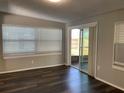 Bright, airy living room featuring dark floors, ample natural light, and a sliding glass door to the outside at 3522 Windham Dr, Holiday, FL 34691