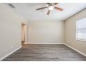 Bright living room featuring neutral walls, modern ceiling fan, and stylish gray wood-look flooring at 3645 6Th S St, St Petersburg, FL 33705