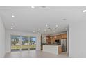 Bright open-concept living space featuring a modern kitchen and large glass doors leading to an outdoor view at 7338 N Ficus Tree, Punta Gorda, FL 33955