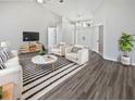 Bright living room with wood floors, a modern rug, and comfortable seating arrangement at 8080 Spanish Oak Dr, Spring Hill, FL 34606