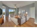 Elegant living room with hardwood floors, neutral paint, and lots of natural light from a large sliding glass door at 1181 Burgos Dr # 406, Sarasota, FL 34238