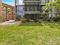 Exterior view of the condo building featuring an enclosed patio and lush green lawn at 612 Bird Bay S Dr # 113, Venice, FL 34285