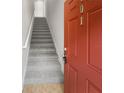 Bright entryway featuring a carpeted staircase and a vibrant red door at 8110 Enclave Way # 101, Sarasota, FL 34243