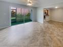 Spacious tiled living room with a ceiling fan and screened patio access to kitchen at 3425 41St S Ter # 202, St Petersburg, FL 33711