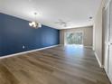 Bright living room boasts wood-look floors, recessed lighting, a sliding glass door, and a modern chandelier at 6507 Stone River Rd # 310, Bradenton, FL 34203