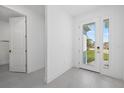 Bright entryway featuring neutral walls, gray tile flooring, and a glass paneled door with a view to the outside at 7443 S Seagrape Rd, Punta Gorda, FL 33955