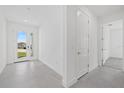 Bright entryway featuring neutral walls, gray tile flooring, and a glass paneled door with a view to the outside at 7443 S Seagrape Rd, Punta Gorda, FL 33955