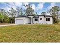 Inviting single-story home with a lush green lawn and a bright white exterior against a partly cloudy sky at 18399 Hillsborough Blvd, Port Charlotte, FL 33954