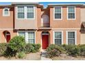 Charming two-story townhouse featuring a well-manicured lawn and vibrant red front door at 8840 Red Beechwood Ct, Riverview, FL 33578