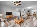 Cozy living room featuring plush seating, ceiling fan, and seamless flow into the dining area at 8869 White Sage Loop, Lakewood Ranch, FL 34202