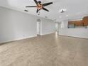 An open-concept living room features tile floors, a ceiling fan, and access to the kitchen at 11535 52Nd E Ct, Parrish, FL 34219