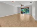 This expansive living room includes neutral decor, tile flooring, and ceiling fan at 11535 52Nd E Ct, Parrish, FL 34219