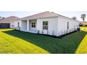 The backyard offers a covered patio and lush landscaping with newly planted shrubbery along the home's perimeter at 25372 Alicante Dr, Punta Gorda, FL 33955