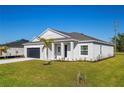 Attractive single-story home with a well-kept lawn and landscaping, as well as a dark gray garage door at 25372 Alicante Dr, Punta Gorda, FL 33955