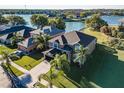 Beautiful home with an attached garage, lush lawn and mature palms on a waterfront lot at 31028 Baclan Dr, Wesley Chapel, FL 33545