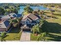 Lovely two-story home features a manicured lawn, mature palms, and stunning lake views at 31028 Baclan Dr, Wesley Chapel, FL 33545