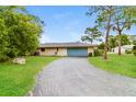 Lovely single-story home featuring a well-manicured lawn, long driveway, and a blue garage door at 4337 Marine Pkwy, New Port Richey, FL 34652