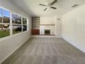 Light-filled living room features a fireplace, ceiling fan, and a large window at 120 W Wildwood St, Tampa, FL 33613