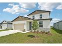 Charming two-story home featuring a 2-car garage, stone accents, and a well-manicured lawn at 31653 Wild Grape Ln, Brooksville, FL 34602