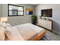 Cozy bedroom with a plush bed, modern dresser, television, and stylish decor at 322 Hoffman Blvd, Tampa, FL 33612