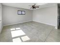 Empty room with neutral walls, tile floor, a ceiling fan, and a black-framed window at 322 Hoffman Blvd, Tampa, FL 33612