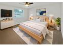 Cozy bedroom with a wooden bed frame, a TV, and a comfortable rug at 4907 E Clifton St, Tampa, FL 33610