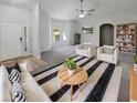 Bright living room showcasing neutral walls, plush seating, stylish rug, ceiling fan, and ample natural light at 6191 Silverdale Ave, Spring Hill, FL 34608