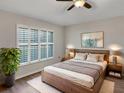 Cozy bedroom featuring a wooden bed, natural light from plantation shutters, and stylish bedside decor at 6721 Somerset Garden Way, Apollo Beach, FL 33572
