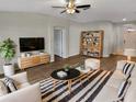 Bright and inviting living room showcasing modern furnishings, stylish decor, and sleek hardwood flooring at 6721 Somerset Garden Way, Apollo Beach, FL 33572