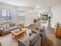 Bright living room with modern furnishings, large windows, and an open floor plan to the dining area at 6856 Ripple Pond Loop, Zephyrhills, FL 33541