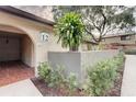 Charming unit entrance with a well-kept garden, beautiful plants, and an inviting arched entry at 6262 142Nd N Ave # 1203, Clearwater, FL 33760