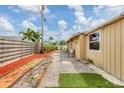 Open backyard with newly renovated grass area and a view of the home's exterior at 3803 Pin Oaks St, Sarasota, FL 34232