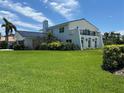 A striking view of the house showcasing lush green lawns, mature trees, and architectural details at 5900 Leeland S St, St Petersburg, FL 33715