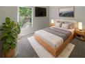 Bright bedroom features a modern platform bed, soft rug, and a large window with natural light and views at 11823 Derbyshire Dr, Tampa, FL 33626