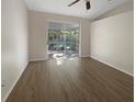 Bright living room with modern decor, a ceiling fan, and a sliding glass door to the lanai at 11823 Derbyshire Dr, Tampa, FL 33626