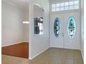 Bright foyer featuring tiled floors, decorative glass double doors, and an arched opening to dining room at 2317 Valrico Forest Dr, Valrico, FL 33594