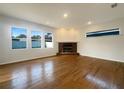Spacious living room features wood flooring, a brick fireplace, recessed lighting, and large windows at 2317 Valrico Forest Dr, Valrico, FL 33594