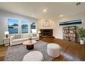 Cozy living room with a brick fireplace, wood floors, large windows, and stylish furnishings at 2317 Valrico Forest Dr, Valrico, FL 33594