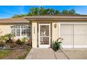 Close-up of the front door with decorative screen, fresh plantings, and attached two car garage at 3699 N Chamberlain Blvd, North Port, FL 34286